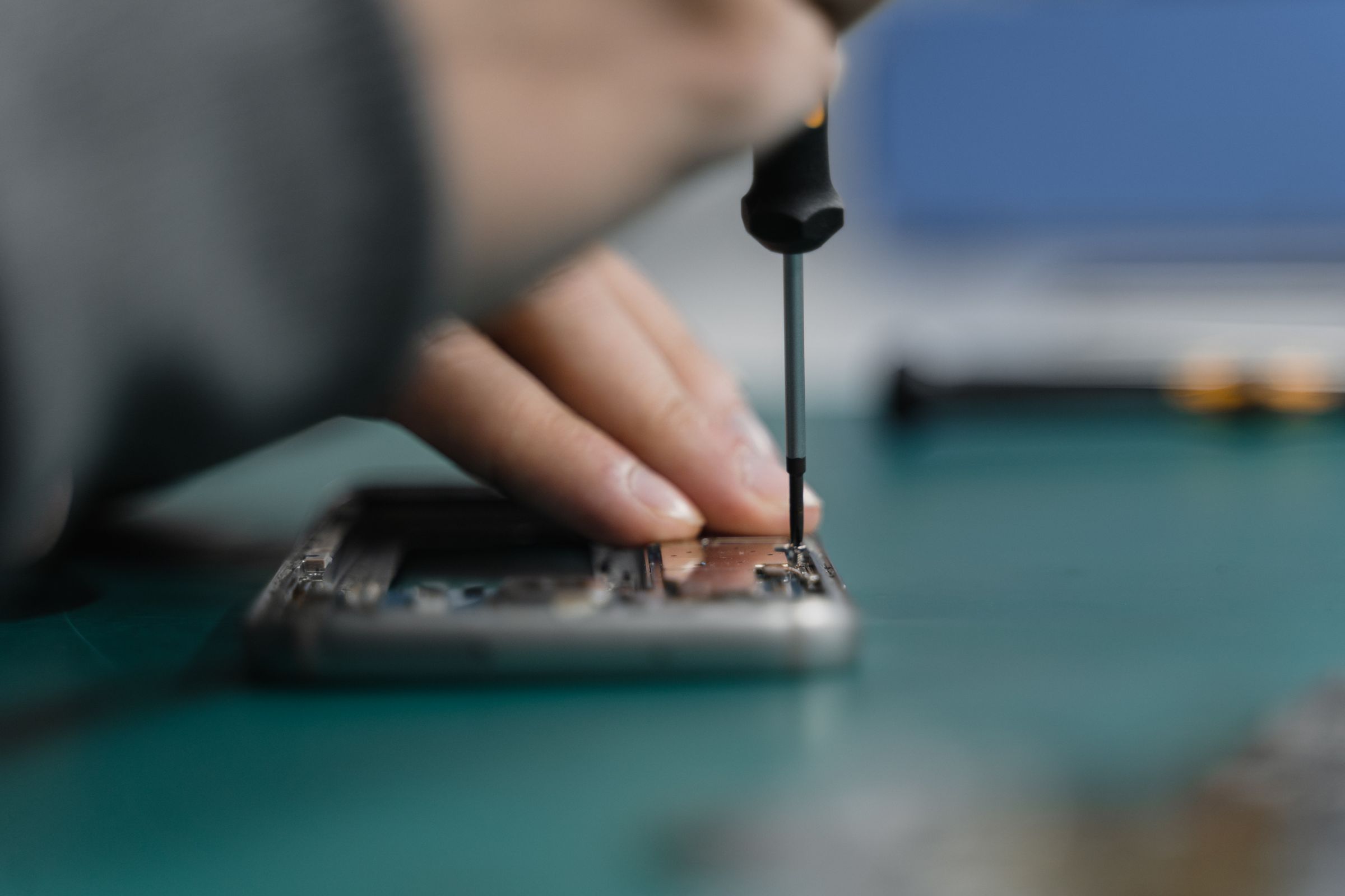 Technician repairing a smartphone with a precision screwdriver