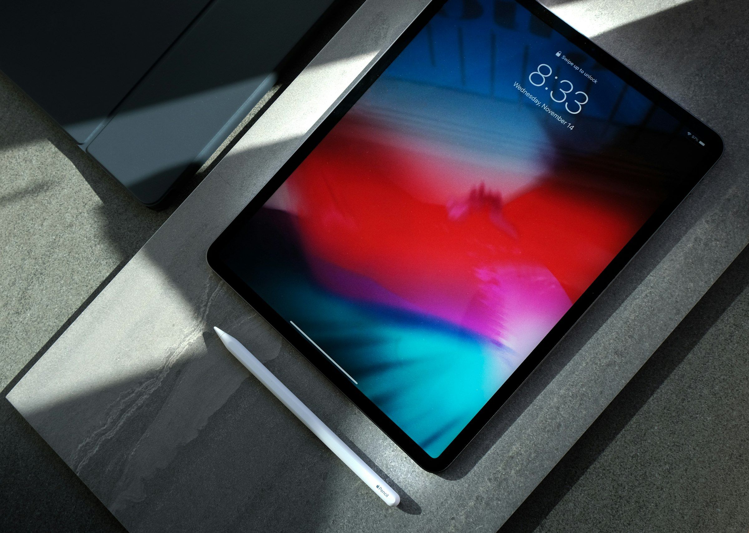 iPad Pro with an Apple Pencil on a stone countertop