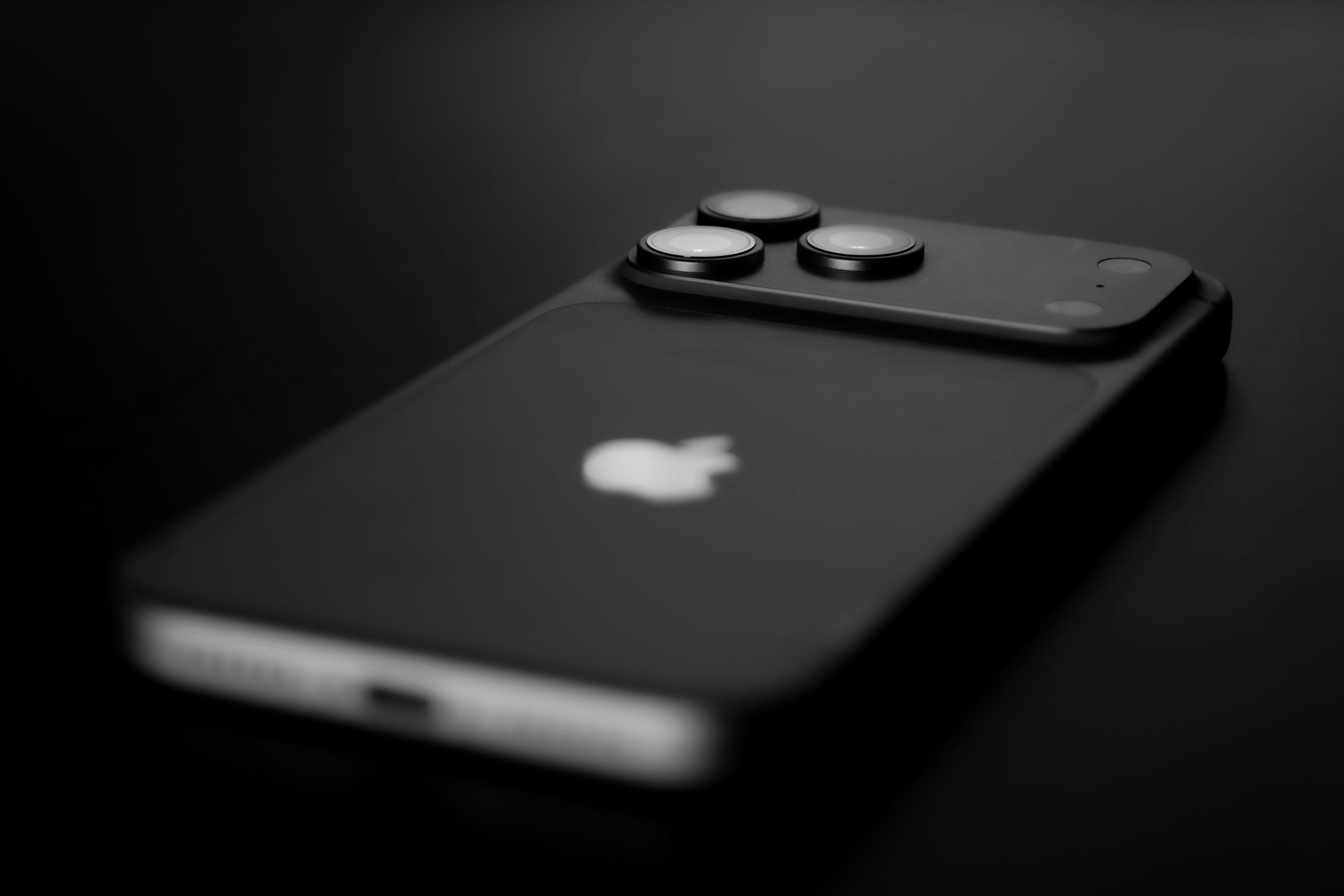 Back of a black iPhone with its triple camera