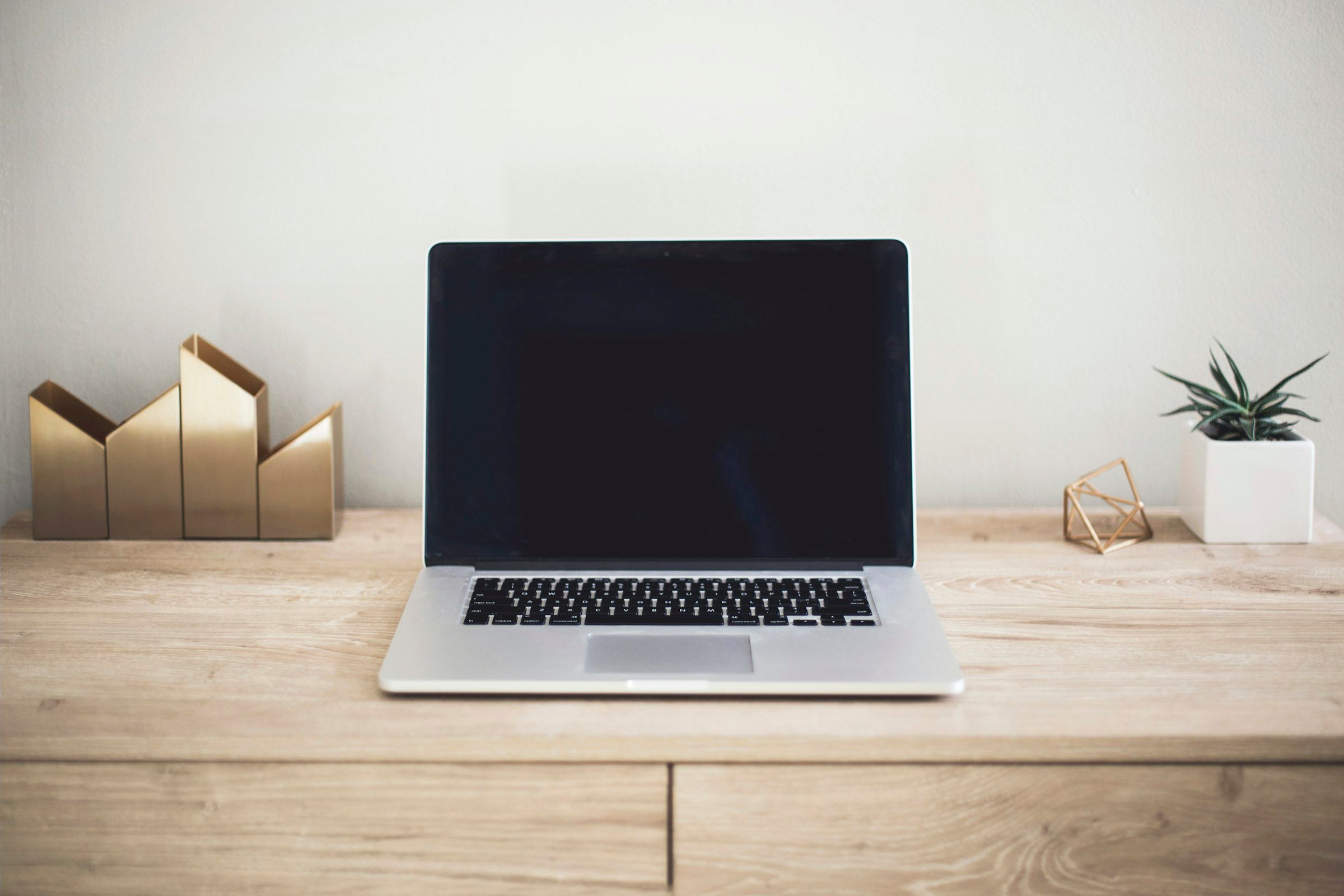 MacBook Pro open on a wooden desk